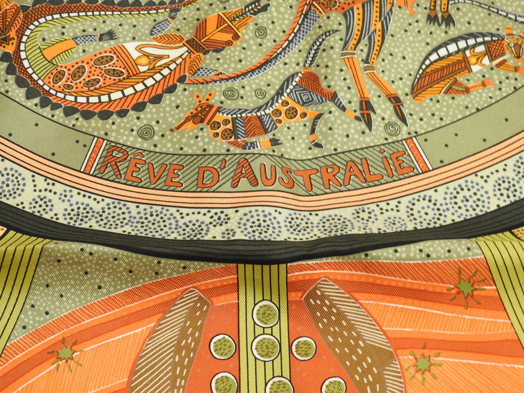 Close up picture of Reve d'Australie, a green, orange and brown Hermes 90cm silk scarf issued in 2000. Designed by Zoe Pauwels, it celebrates Australian wildlife