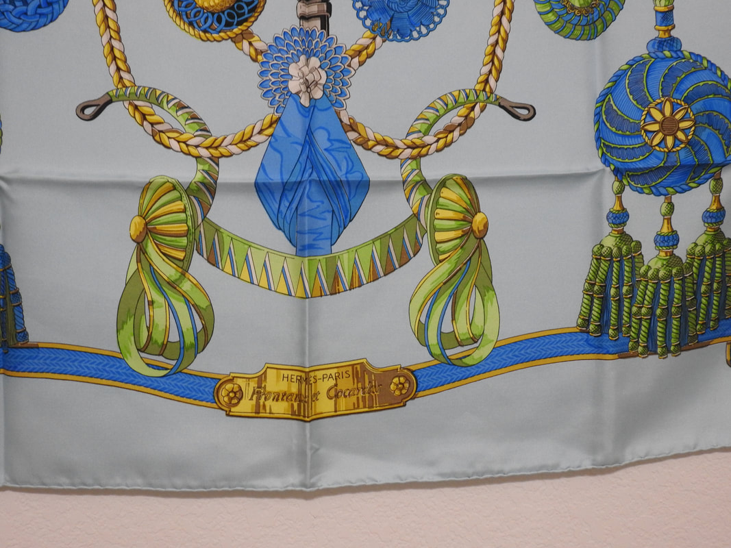 Close up picture of the Hermes brand appearing in a used Hermes scarf Frontaux et Cocardes