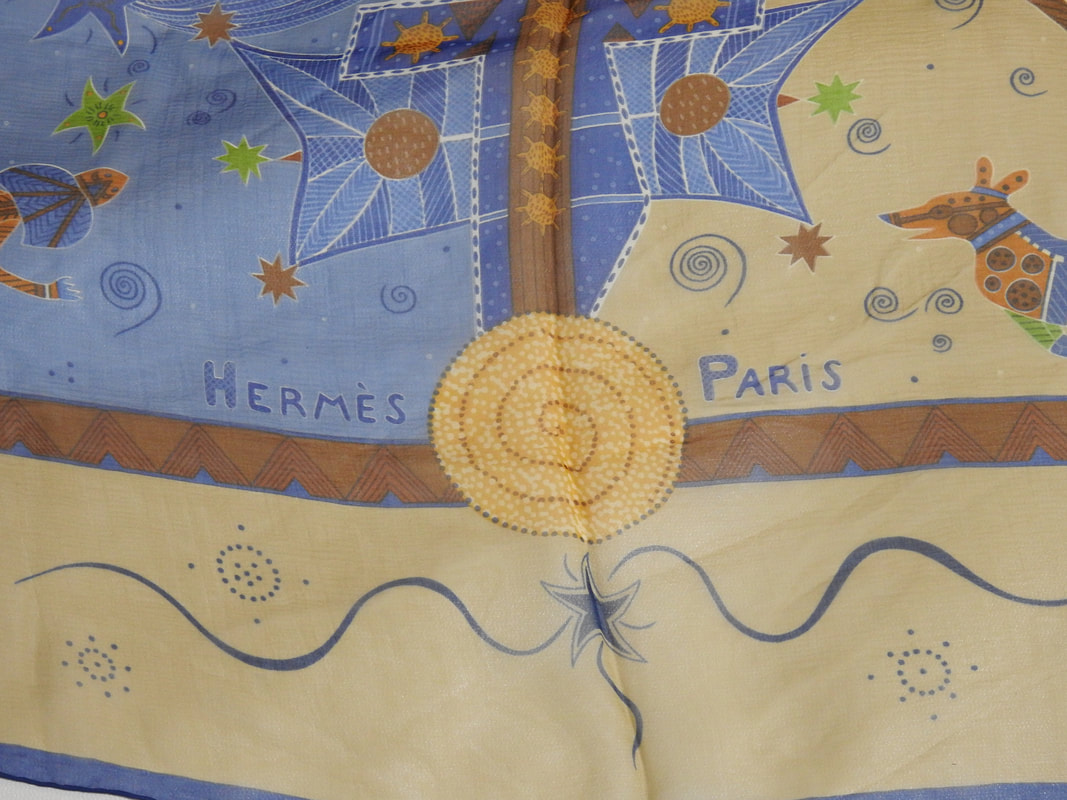 Close up picture of the Hermes brand appearing in a used Hermes 140cm silk mousseline scarf Reve d'Australie