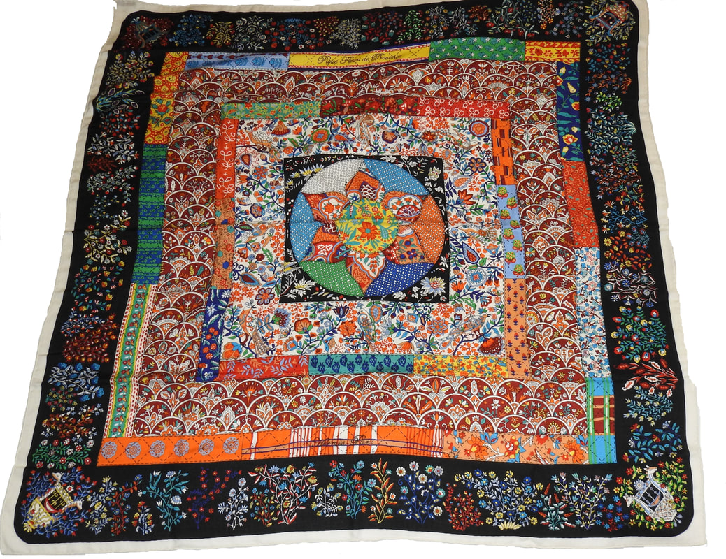Picture of Pique Fleuri en Provence, a vintage Hermes 140cm silk cashmere scarf designed by Christine Henry. Black background with floral designs of blue, green, yellow, orange and white