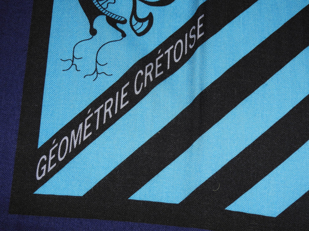 Close up picture of Geometrie Cretoise, a blue Hermes 140cm silk and cashmere scarf issued in 2012. Designed by Julia Abadie, it celebrates Cretian art
