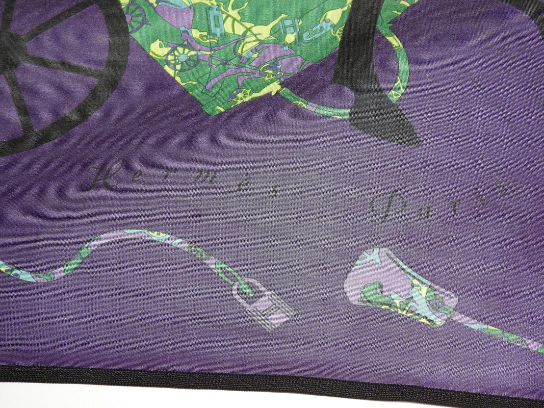 Close up picture of the Hermes brand appearing in a used Hermes scarf Kelly en Caleche