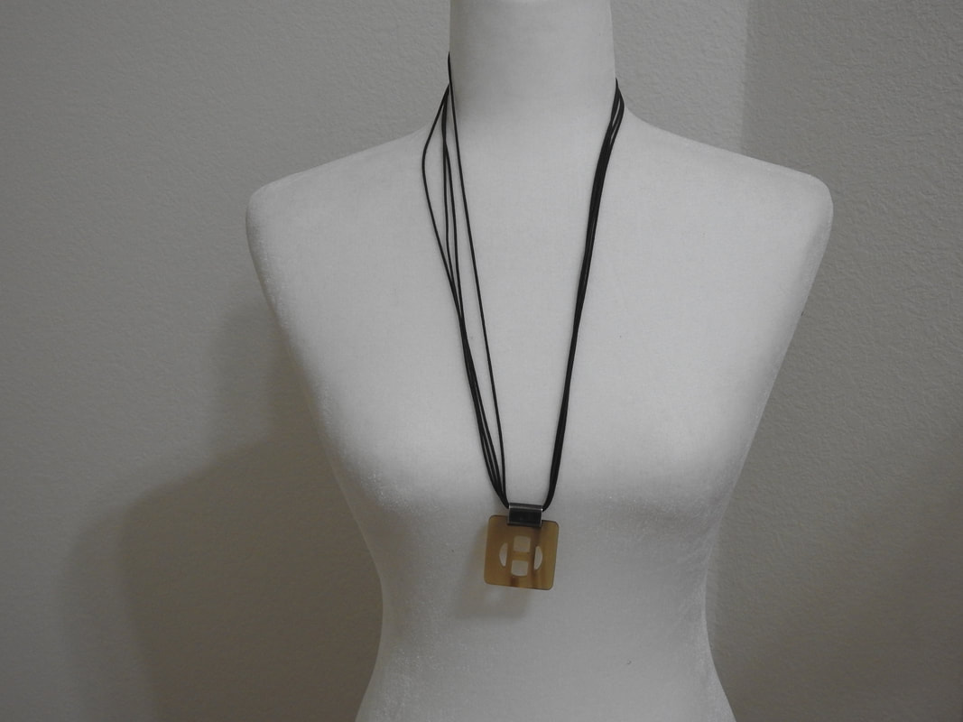 Picture of Hermes buffalo horn necklace on adjustable leather cord. H shaped pendant.