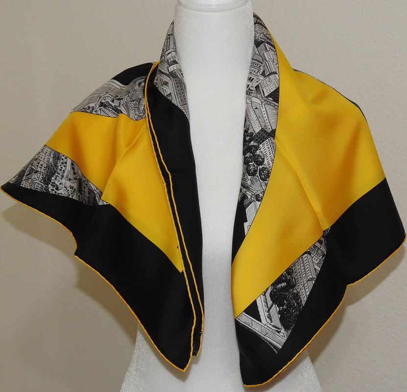 Picture of Regarde Paris, a pre-owned Hermes 90cm silk scarf for sale. This yellow, white and black colorway is tied simply in an asymmetrical  fold