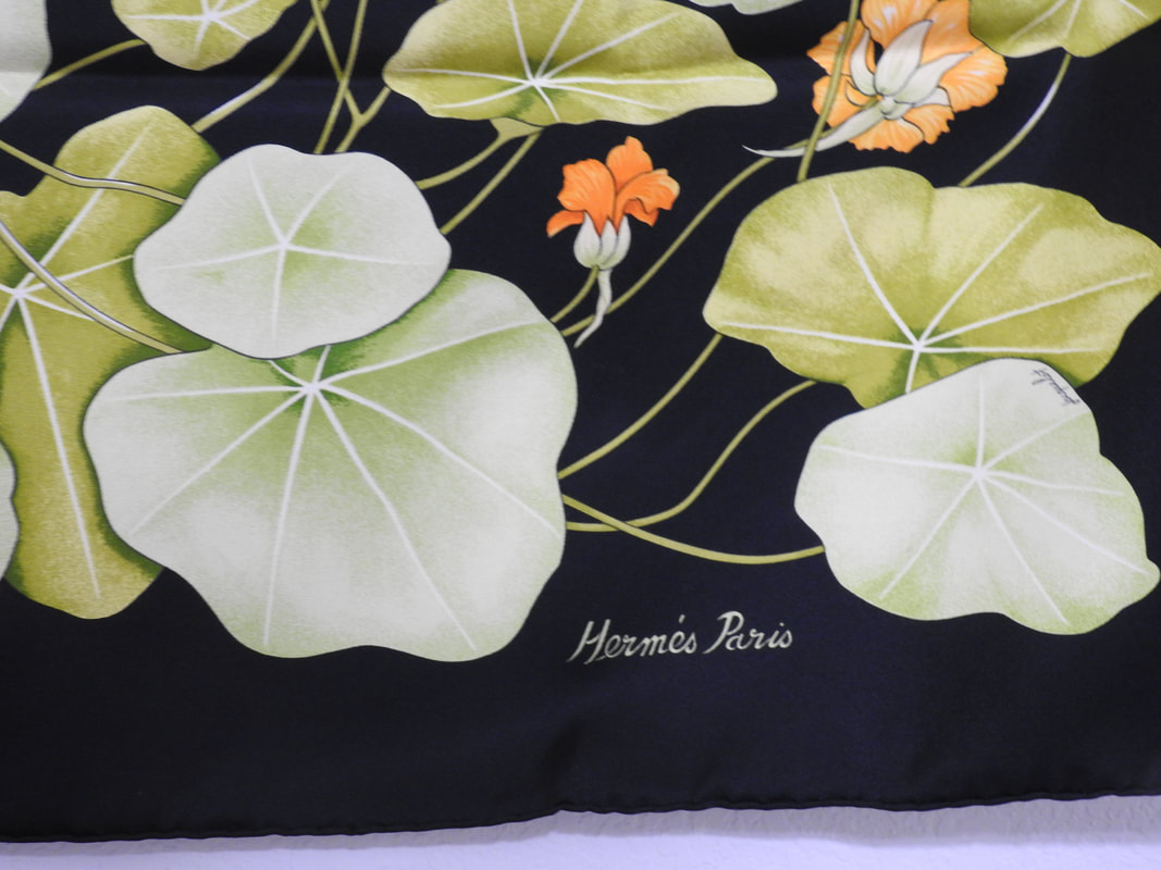 Close up picture of the Hermes brand appearing in a used Hermes scarf Les Capucines