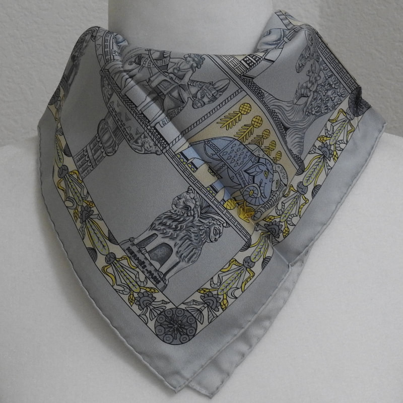 Picture of a 45cm Hermes silk scarf, Torana by Annie Faivre in a light blue.. Tied in a simple cowboy knot