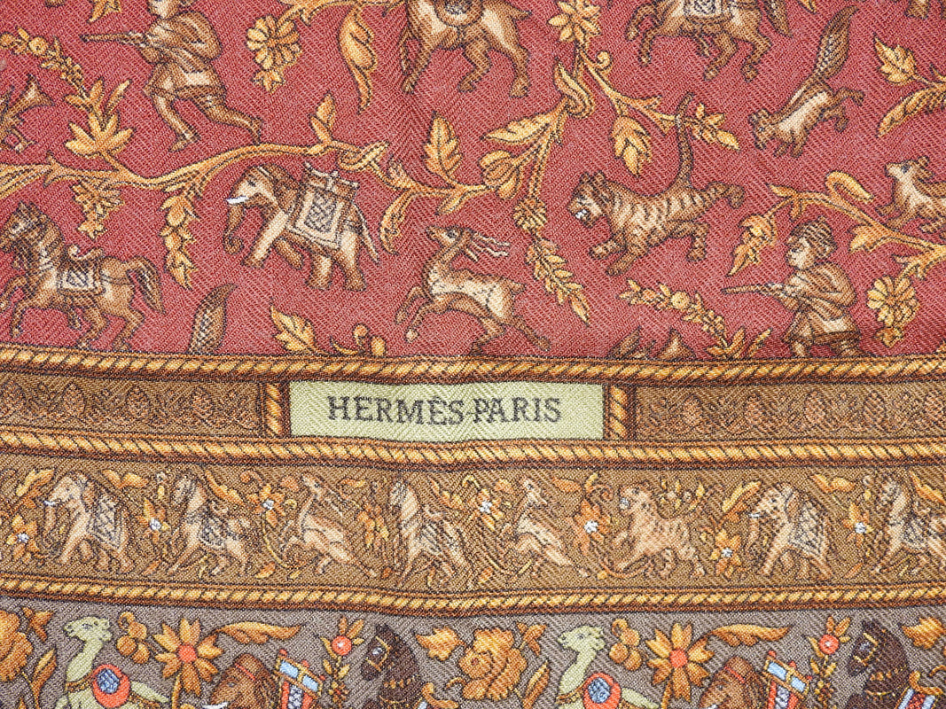 Close up picture of the Hermes brand appearing in a used brown Hermes cashmere 90cm scarf Chasse en Inde