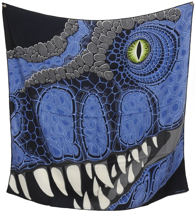 Picture of Aaaaargh!, an Hermes scarf designed by Alice Shirley. Blue dinosayr with green eye against a navy blue background