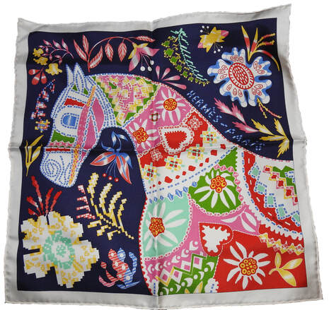 Picture of En Attendant Ulysse, a 45cm silk scarf designed by Florence Manlik for Hermes. A horse of red, yellow, pink green and blue florals again a navy background held by a white border