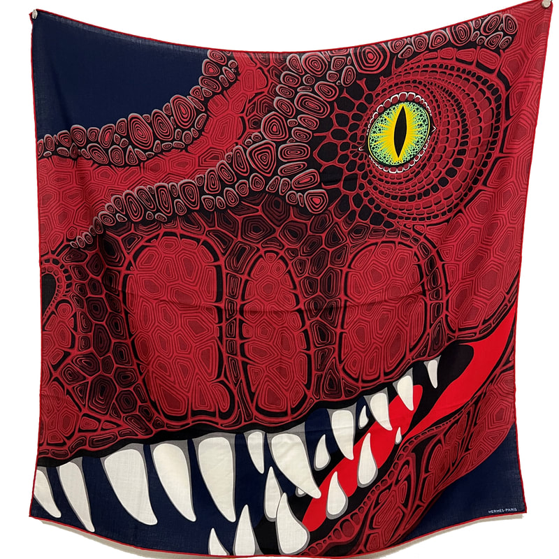Picture of Aaaaargh!, an Hermes men's 100cm cashmere scarf. Red dinosaur with a green eye against a navy blue background
