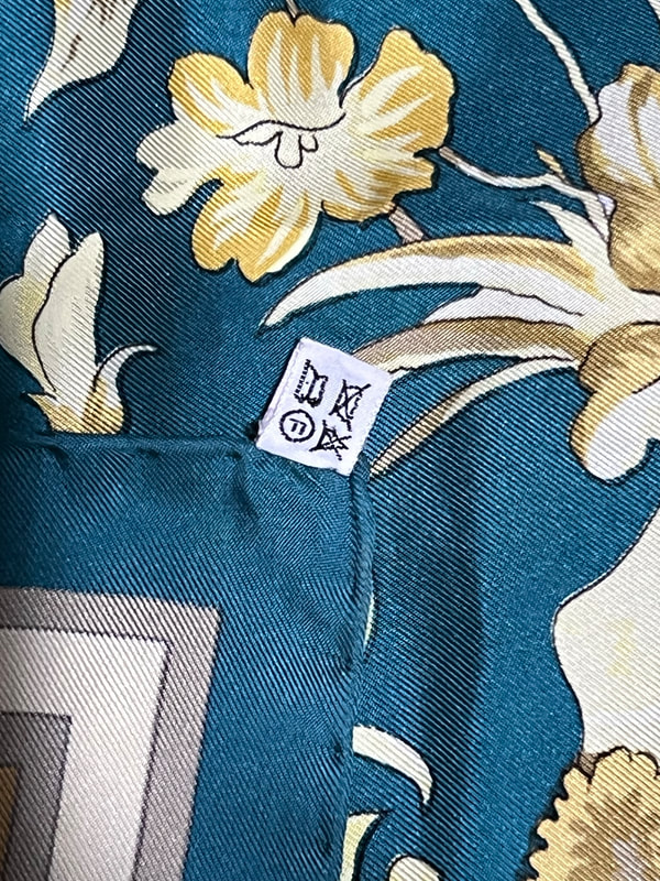 Picture of used Hermes 90cm silk scarf for sale. Monsieur et Madame by Bali Barret, brown and goldue with star jacquard weave. Knotted loosely around the neck