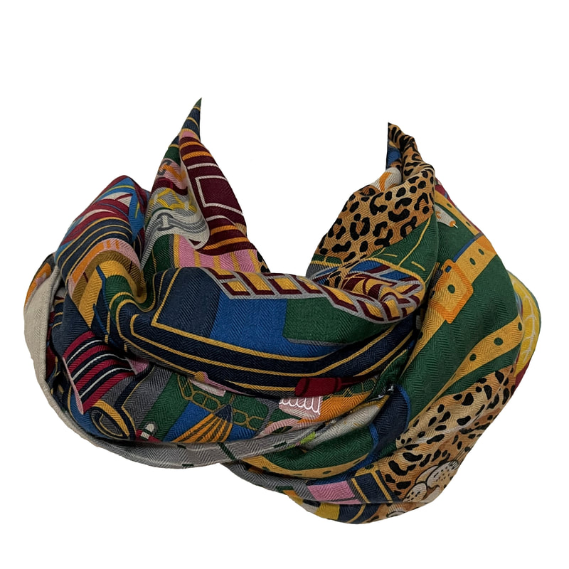 Picture of Les 12 Leopards, a 140cm Hermes scarf made of cashmere and silk, tied in an infinity know to show the blue, yellow and green in the design