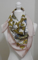 Picture of Les Tambours, a used Hermes silk scarf for sale. This pink colorway is tied in a cowboy knot