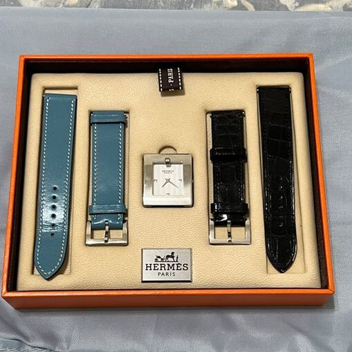 Picture of Hermes Belt Watch. Square Stainless Steel face, interchangeable black alligator and blue leather straps. In original packaging
